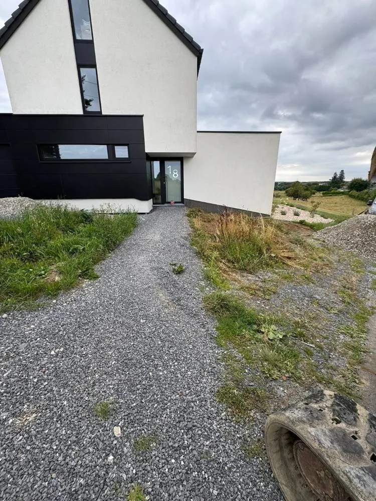 Allée gravier montant vers une maison