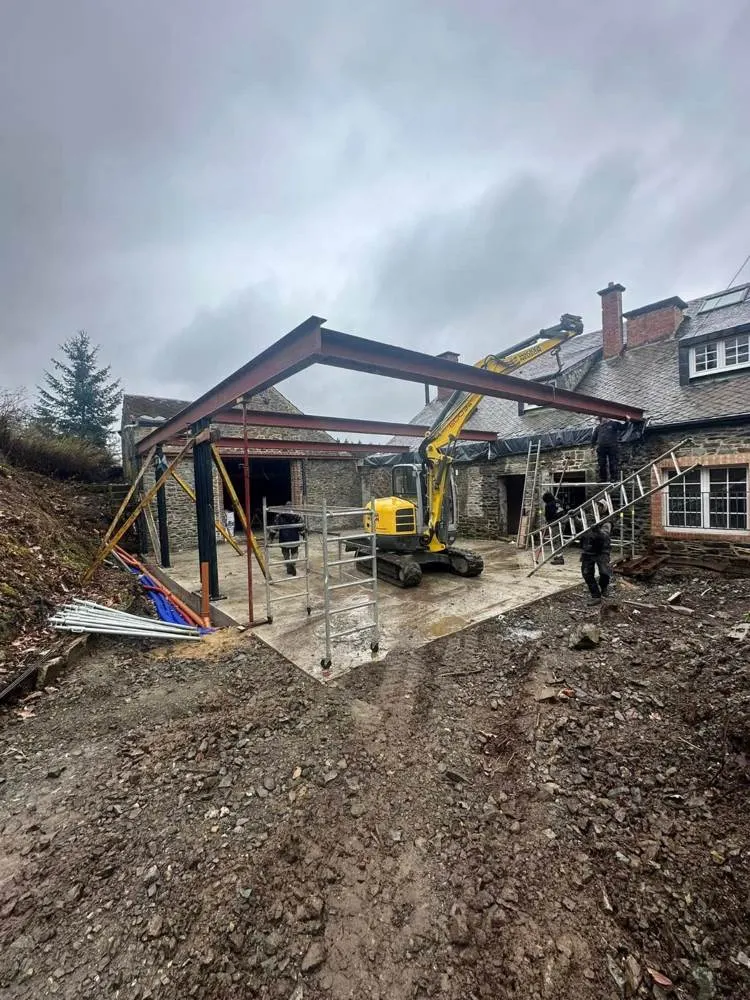 Démolition partielle d'un bâtiment ancien avec pelle