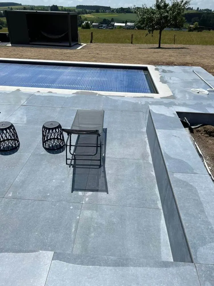 Plage de piscine en béton avec mobilier