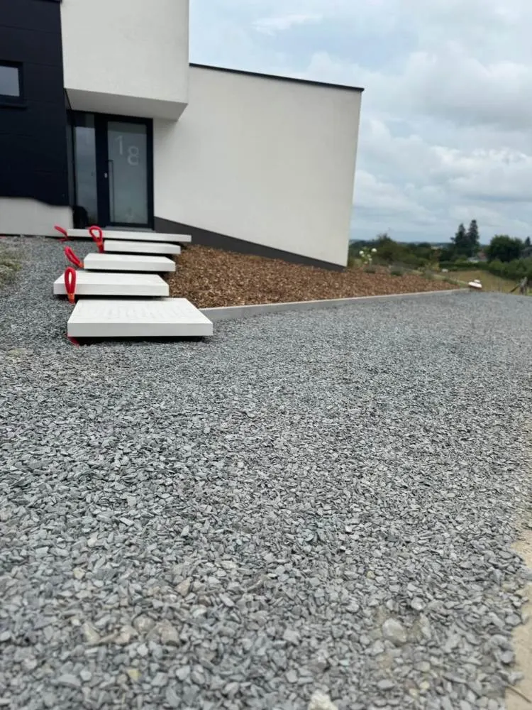 Marches en béton et empierrement devant une maison moderne